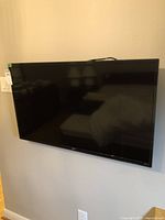 Front view of the wall-mounted Seiki flat-screen television, showing the screen and frame condition.