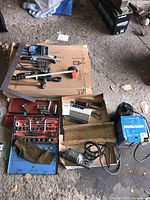 Overview of various plumbing and mechanic tools including a socket wrench set, hand tools, submersible pump, and drill.