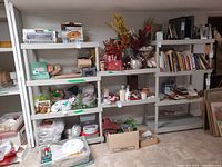 Front view of the three plastic shelving units placed side-by-side with various items on shelves not included in the sale.