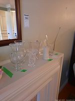 All six vases arranged on a white mantelpiece against a wall with mirror above, showing height and variety.