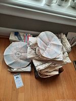 View of the lot showing fabric, sewing pattern charts, and parts of boxed items with craft supplies