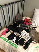 Overall lot of vintage gloves and purses arranged on bed and chair, showing color variety and quantity