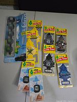 Photo of nine unopened car air fresheners with packaging visible, including Little Trees and Febreze mini fresheners.