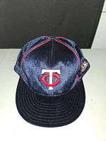 Front view of the navy blue velour fitted baseball hat showing the embroidered white and red Minnesota Twins logo on the front.