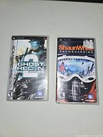 Front covers of two PSP game cases: Tom Clancy's Ghost Recon Advanced Warfighter and Shaun White Snowboarding.