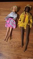 Two full-size fashion dolls: blonde Barbie and Julia doll in yellow coat