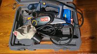 Ryobi electric hand planer with power cable and dust bag placed inside carrying case