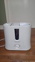 Front view of the white Honeywell humidifier showing the water level indicator and control knob.
