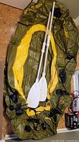Photo of the inflated boat with two white oars placed inside, showing valves, brand markings and color detail
