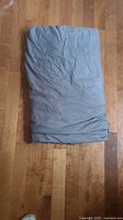 Folded grey microfiber duvet cover shown on hardwood floor