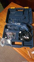 Open carrying case displaying Mastercraft rotary tool with various attachments organized in compartments inside.