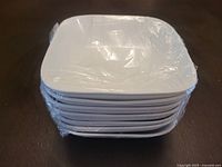 Stack of 7 white square ceramic bowls wrapped in plastic wrap for protection.