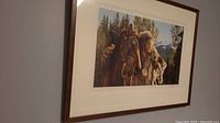 Angled side view of the framed western scene print showing the wooden frame and part of the glass reflecting light.