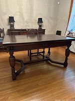 Full view of the antique oak dining table showing the top surface and turned legs.