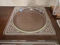 Single square glass plate with raised beading visible on underside and round center