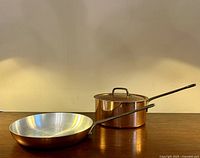 Side view of copper frying pan interior and copper saucepan with lid