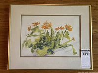 Framed floral watercolor painting featuring orange flowers and green leaves with signature.