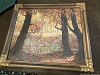 Framed landscape painting showing the full artwork including large trees in foreground and stream leading to distant trees in background.