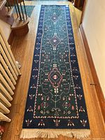 Full-length view of runner on hardwood floor, showing overall pattern, colors and fringe.