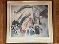 Full view of framed Vasily Kandinsky print showing colorful abstract landscape with red spots and organic shapes.