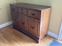 Front and left angled view of vintage birch buffet cabinet showing wood grain and hardware detail.