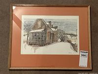 Full view of framed vintage print of an old abandoned house in winter, showing frame and matting.