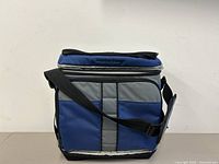 Blue, black and grey Arctic Zone cooler bag with black adjustable shoulder strap, viewed from front and side, showing condition and dimensions.
