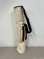 Front angle view standing upright showing canvas bag with single black shoulder strap.