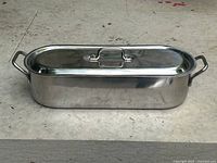 Closed stainless steel fish poacher pot showing the lid and handles.