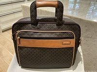 Front view of handbag showing brown diamond-patterned canvas with natural tan leather front panel embossed with 'Eiffel', matching trim, zipper, and double handles with leather grip.