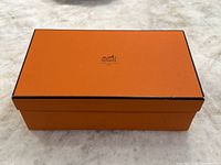Top view of orange Hermes shoebox showing rectangular shape and edge wear.