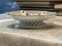 Side profile showing the reticulated lattice edge and pedestal base of the porcelain dish