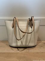 Full front view of off-white leather Michael Kors tote bag showing rectangular shape and straps.
