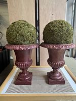 Photo showing pair of metal garden urns with moss topiary balls on top, highlighting overall appearance and dimensions