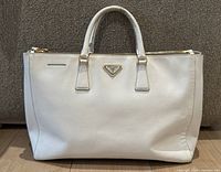 Front view showing Prada triangle logo plaque and overall shape