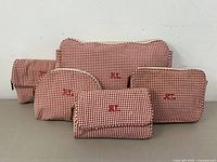 Front view of 5 red and cream gingham Ralph Lauren bags arranged in two rows showing sizes and shapes with red RL embroidery