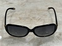 Front view of black Ralph Lauren women's sunglasses showing rectangular dark lenses and glossy frame