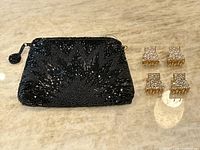 Photo showing the black beaded bag and four gold hair clips with rhinestones and pearls.