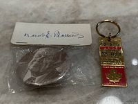 Photo of Harold Ballard pin in plastic packaging with signature backing and Maple Leaf Gardens ticket stub keychain