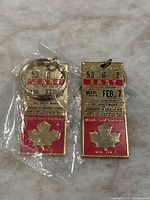 Photo showing two gold-toned metal Toronto Maple Leafs keychains resembling vintage ticket stubs, one in original packaging, the other out of package.