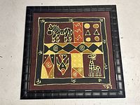 Full view of framed vintage batik tribal art with animal and geometric motifs.