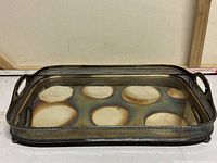 Photo showing the full rectangular tray from an angle highlighting circular tarnish marks on the surface from bottle placement.