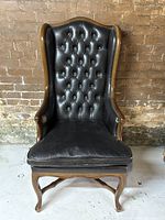 Front view of chair showing tall tufted back and seat cushion
