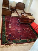Full view of red field area rug under bed frames