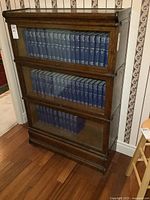 Front view of three-tier oak barrister bookcase with books inside