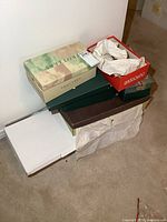 Photo showing several shoeboxes stacked with some shoes partially visible.