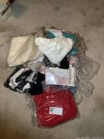 Overview photo showing multiple knitwear items and tights on carpet, some in packaging