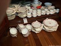 Floor display of bouillon cups and stacks of saucers in front of cabinet
