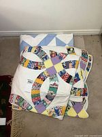Both quilts folded and stacked on floor