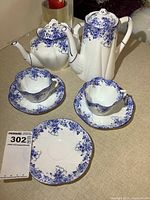 Group shot of coffee pot, teapot, two cups, three saucers